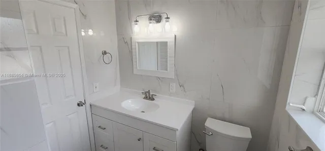 an empty room with wooden floor chandelier fan and windows