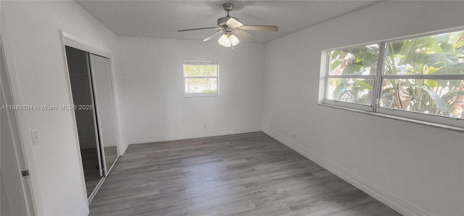 200 Northwest 9th Street Boca Raton, FL 33432 - Photo 26 of 61 an empty room with wooden floor chandelier fan and windows