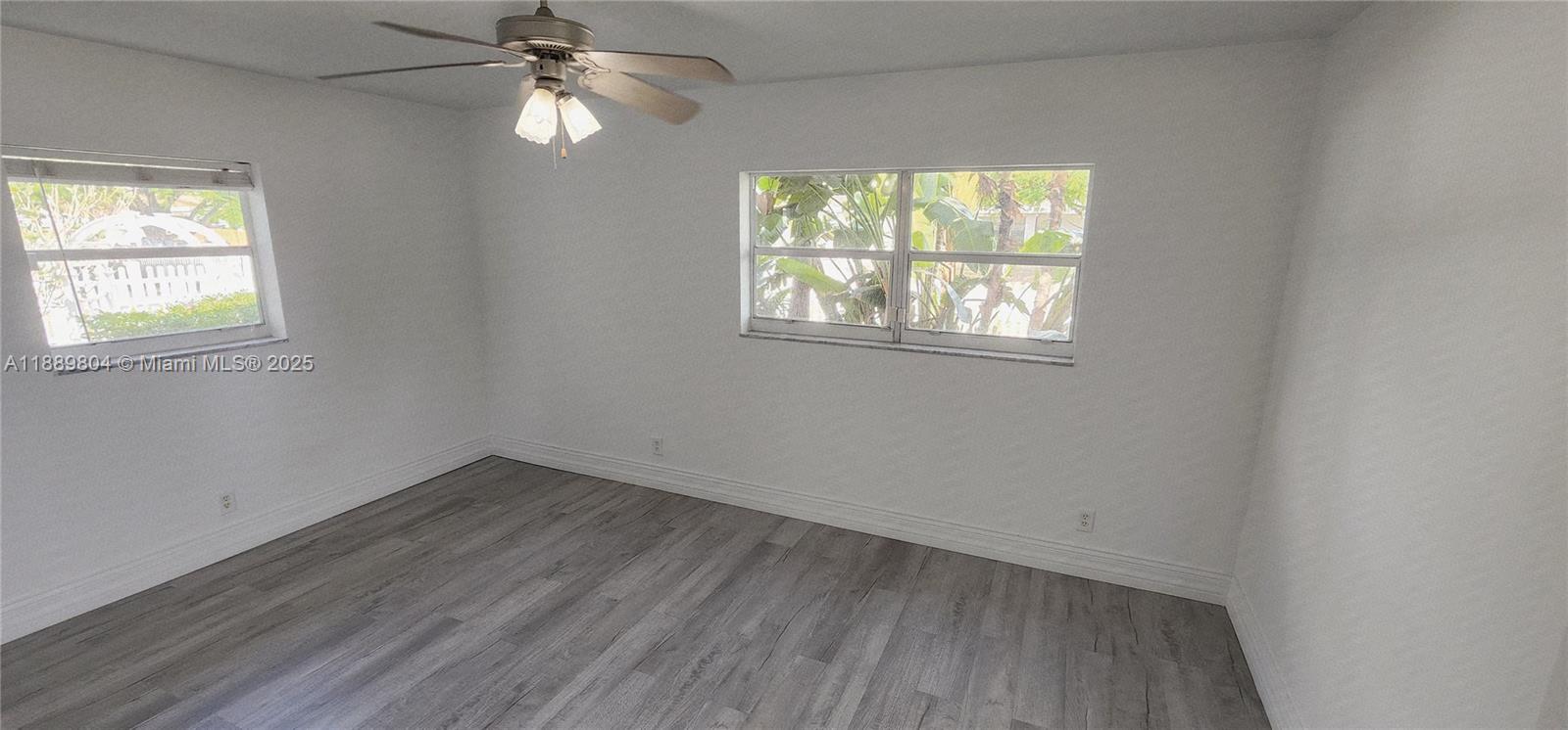 200 Northwest 9th Street Boca Raton, FL 33432 - Photo 27 of 61 an empty room with wooden floor chandelier fan and windows