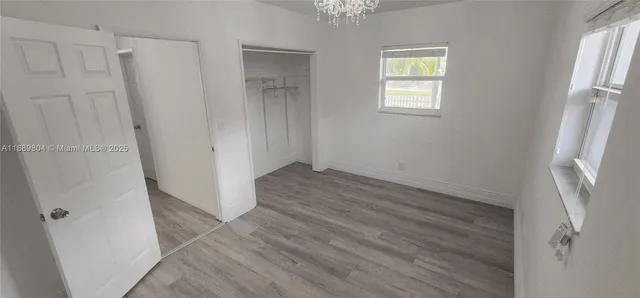 a view of an empty room with window chandelier fan