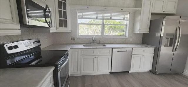 a kitchen with a stove a sink and a refrigerator