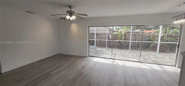 a view of a room with wooden floor and a ceiling fan