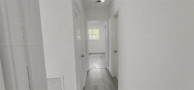 a view of empty room with wooden floor