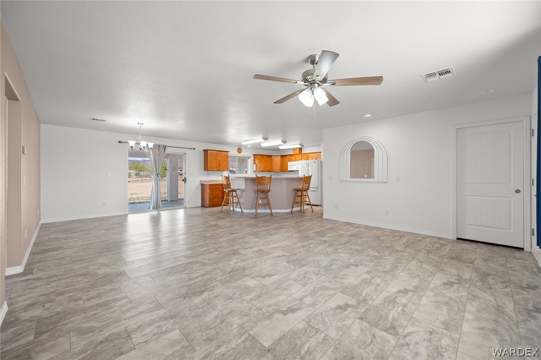 3411 West Carmichael Road Golden Valley, AZ 86413 - Photo 3 of 97 Unfurnished living room featuring ceiling fan and suspended lighting