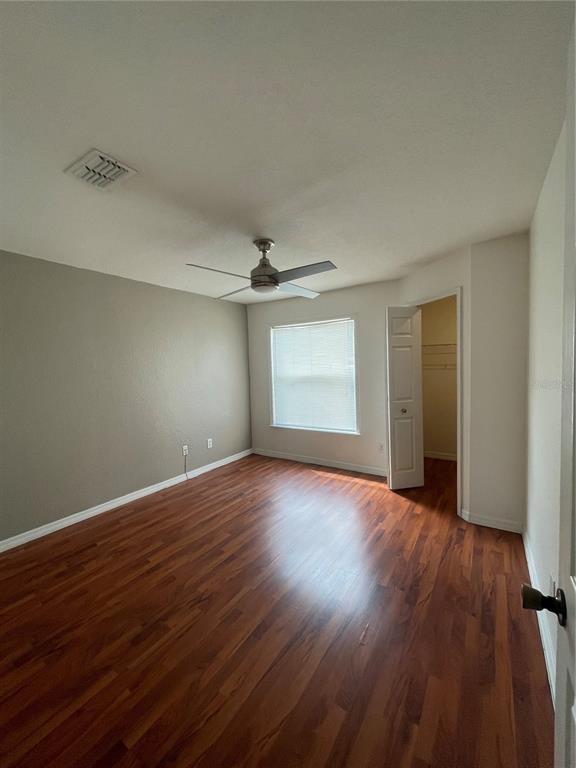 8915 Latrec Avenue, Unit 2307 Orlando, FL 32819 - Photo 3 of 5 an empty room with wooden floor and windows