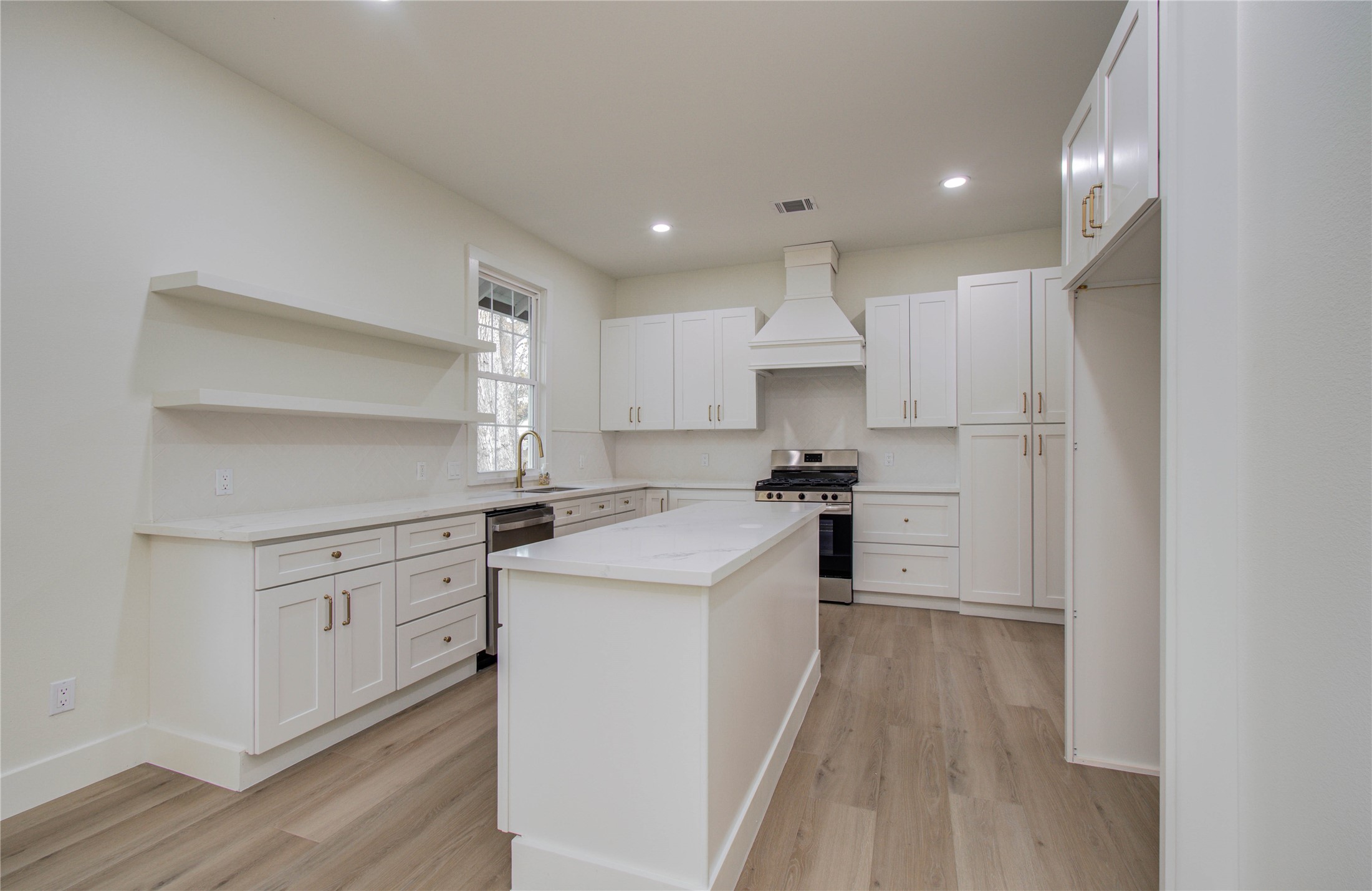727 Travis Street Columbus, TX 78934 - Photo 14 of 36 a kitchen with white cabinets and white appliances