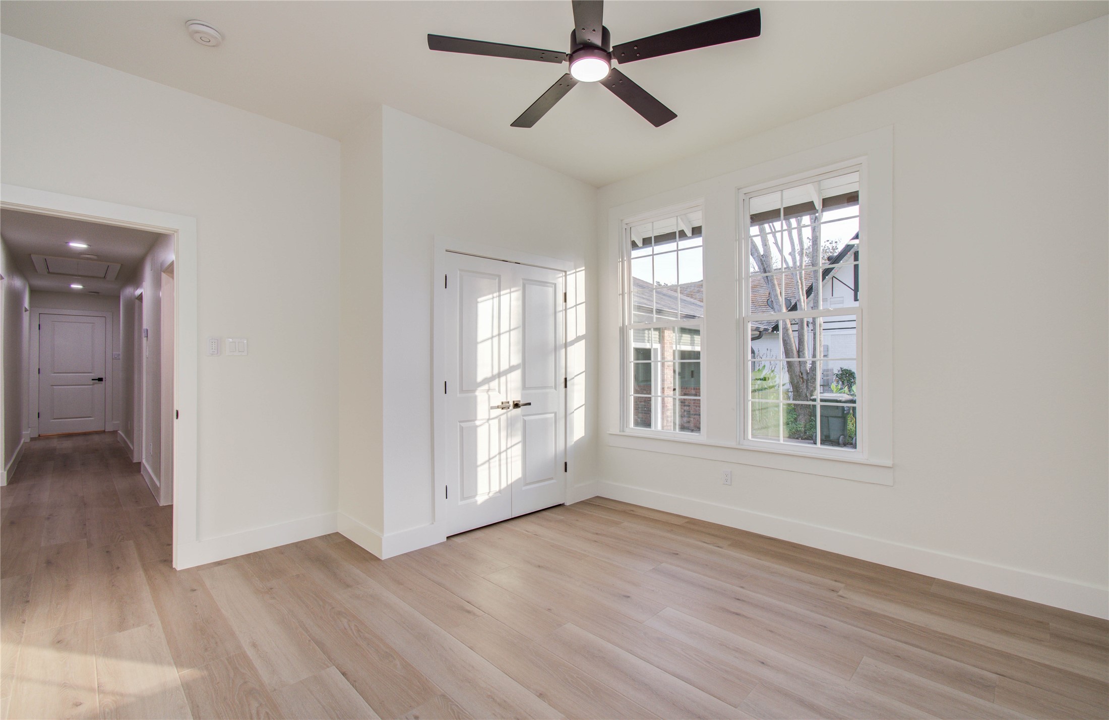 727 Travis Street Columbus, TX 78934 - Photo 18 of 36 an empty room with wooden floor and windows