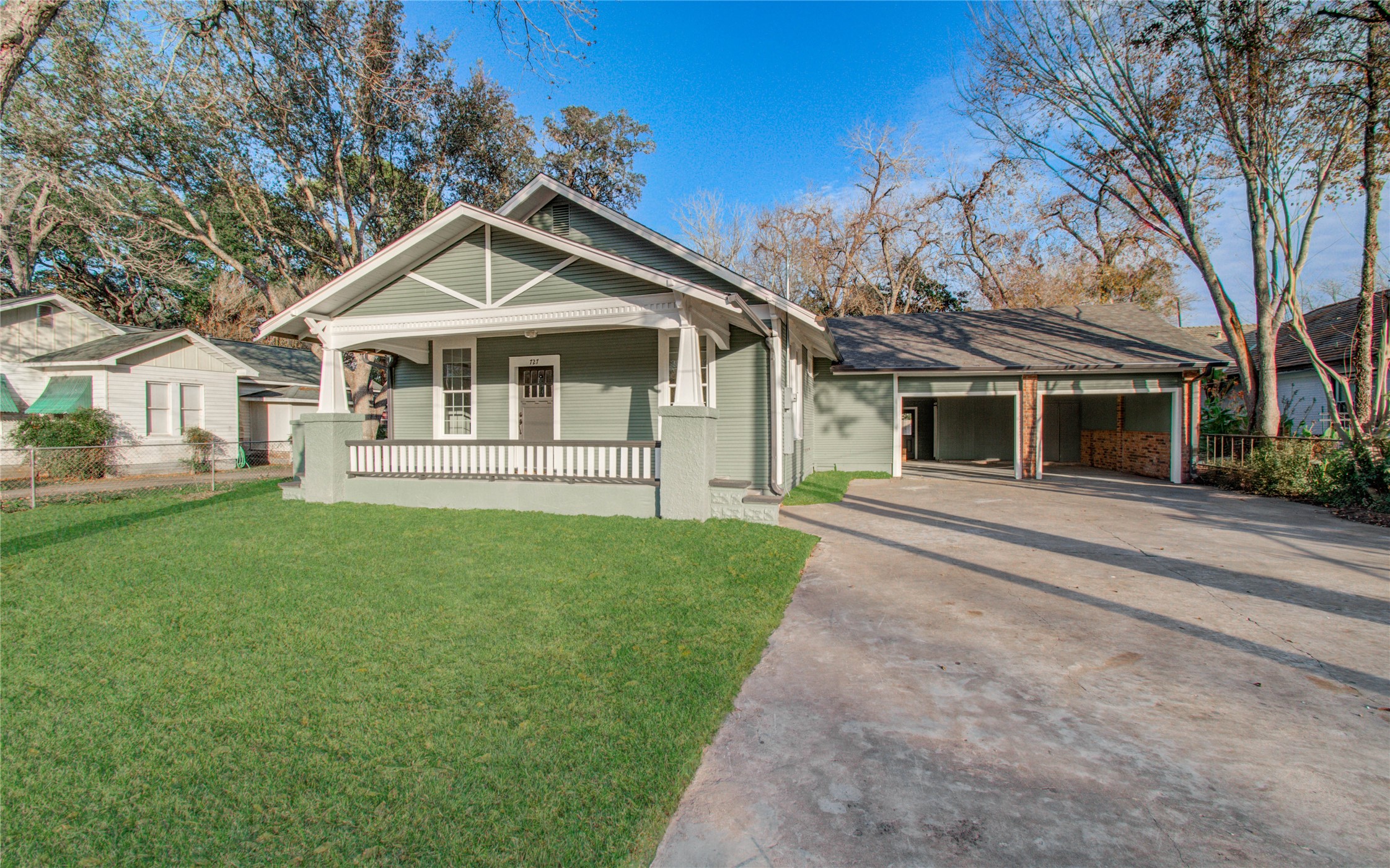 727 Travis Street Columbus, TX 78934 - Photo 2 of 36 a front view of a house with a garden and trees
