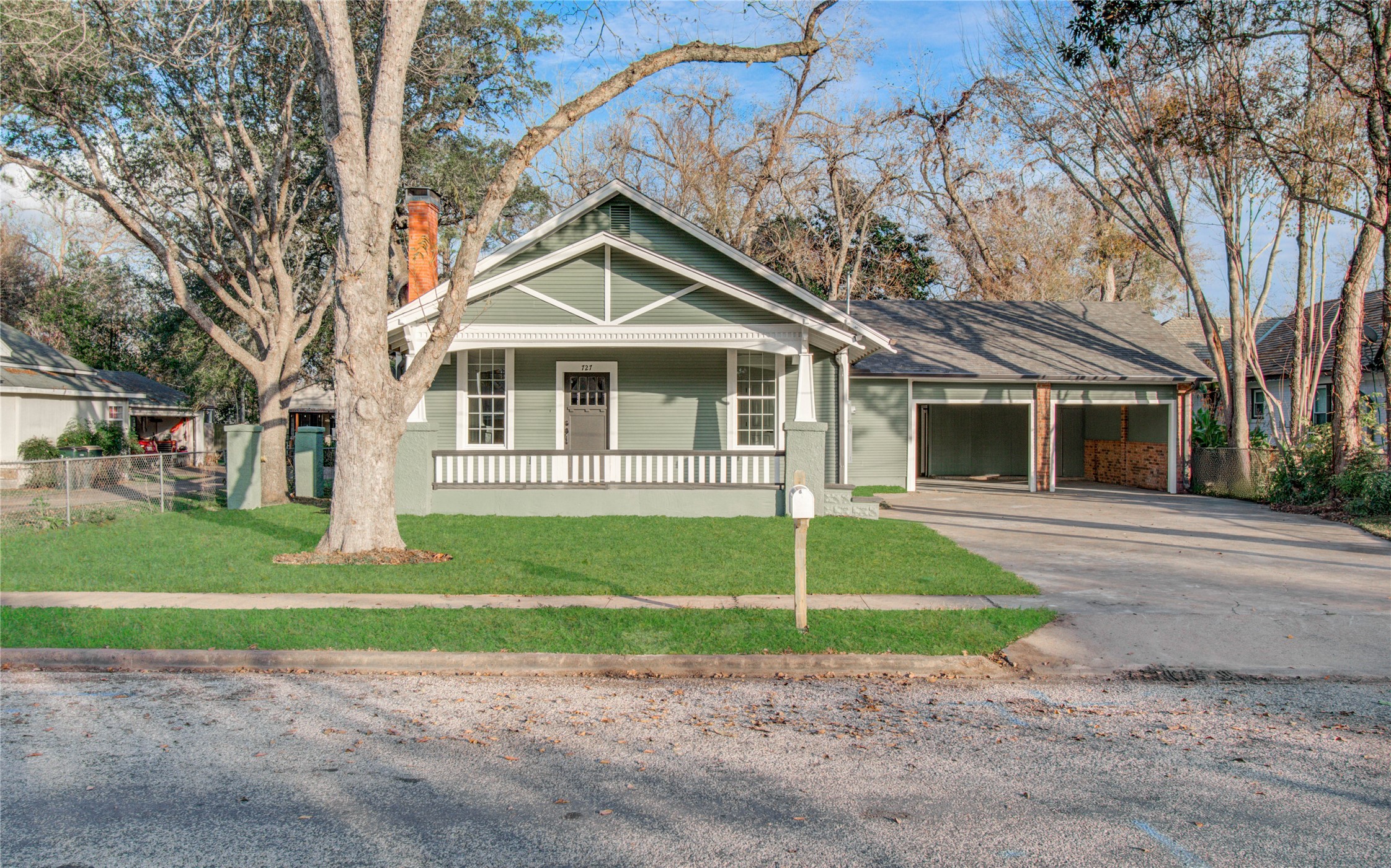 727 Travis Street Columbus, TX 78934 - Photo 3 of 36 a front view of a house with a garden and trees