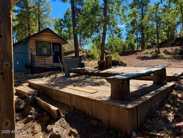 1725 Turkey Mountain Road Happy Jack, AZ 86024 - Photo 31 of 35 a roof deck with table and chairs under an umbrella with large trees