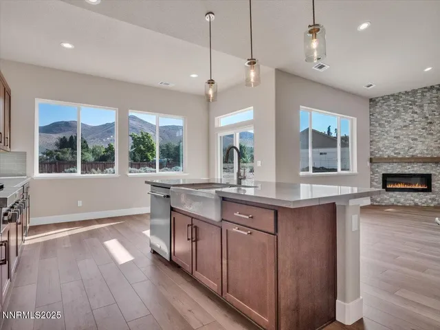 a kitchen with stainless steel appliances granite countertop a sink a stove and a wooden floors
