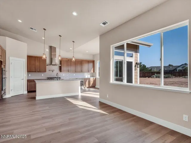 a view of a kitchen with a sink stove cabinets and empty room