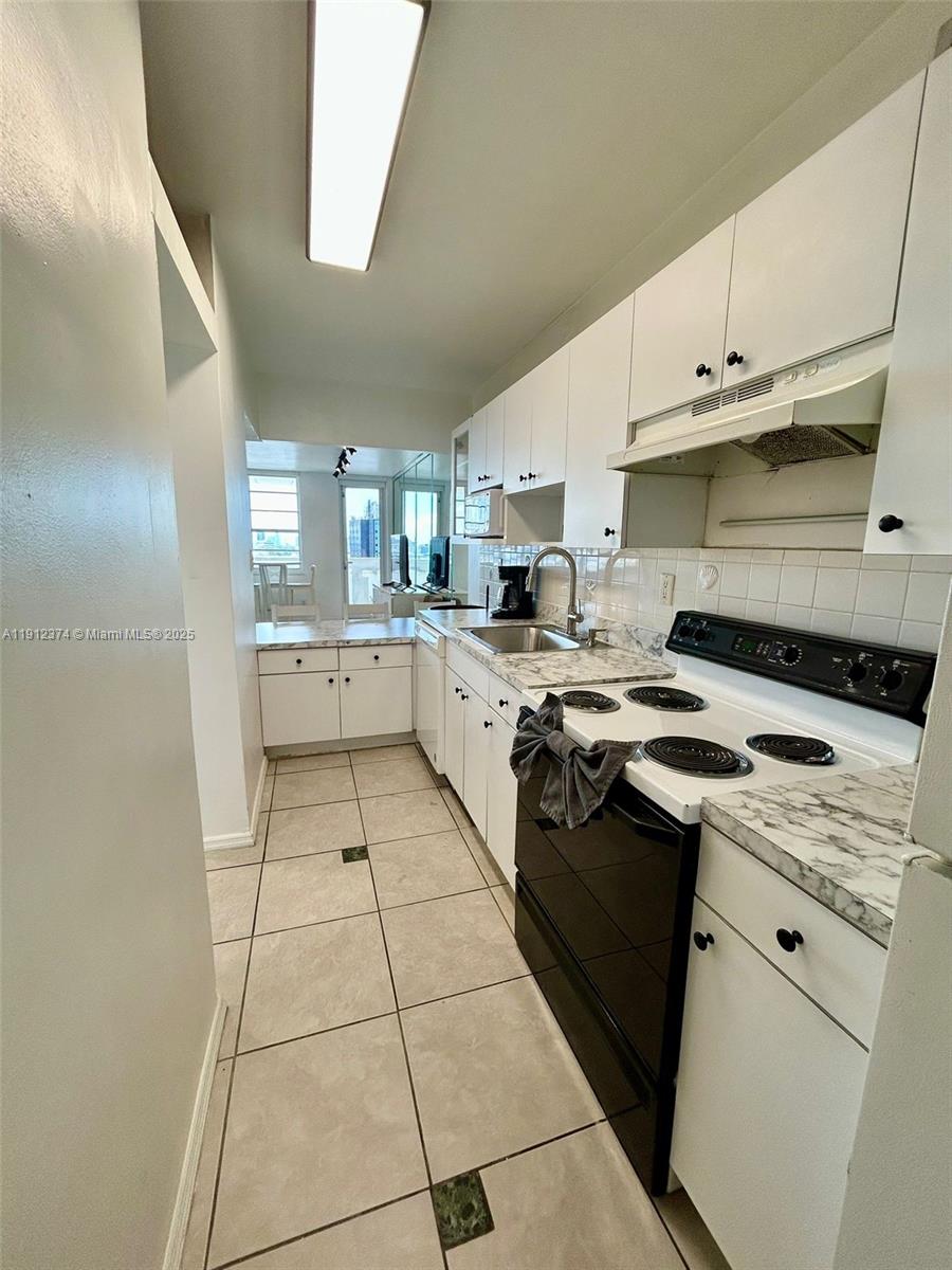 100 Lincoln Road, Unit 1220 Miami Beach, FL 33139 - Photo 5 of 10 a kitchen with a sink a stove and cabinets