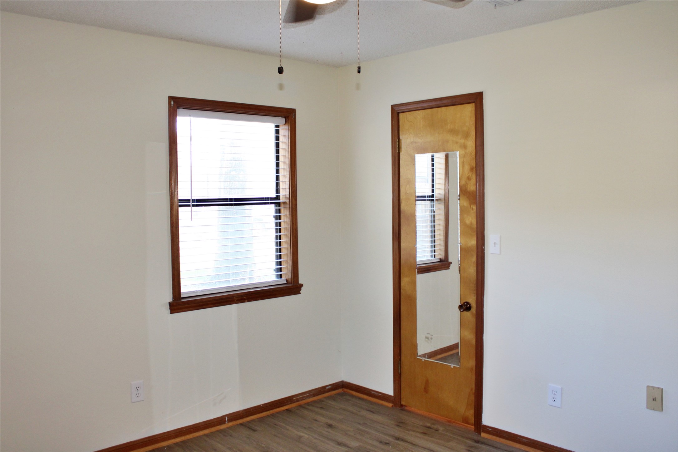 1126 Jackson Street Columbus, TX 78934 - Photo 13 of 40 a view of an empty room with wooden floor and a window