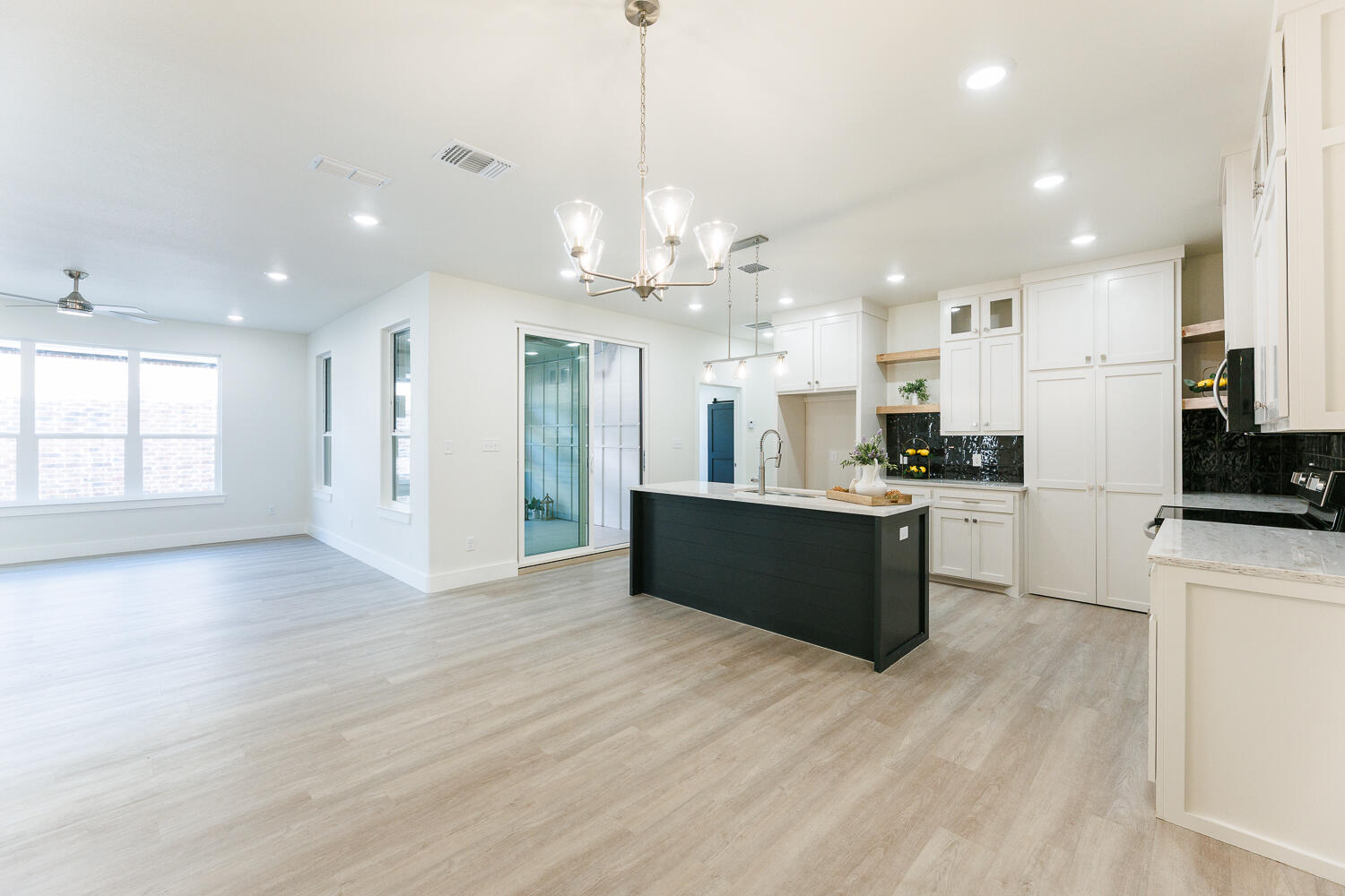 3819 58th Street Lubbock, TX 79413 - Photo 13 of 63 a large kitchen with granite countertop a large counter top a refrigerator and cabinets