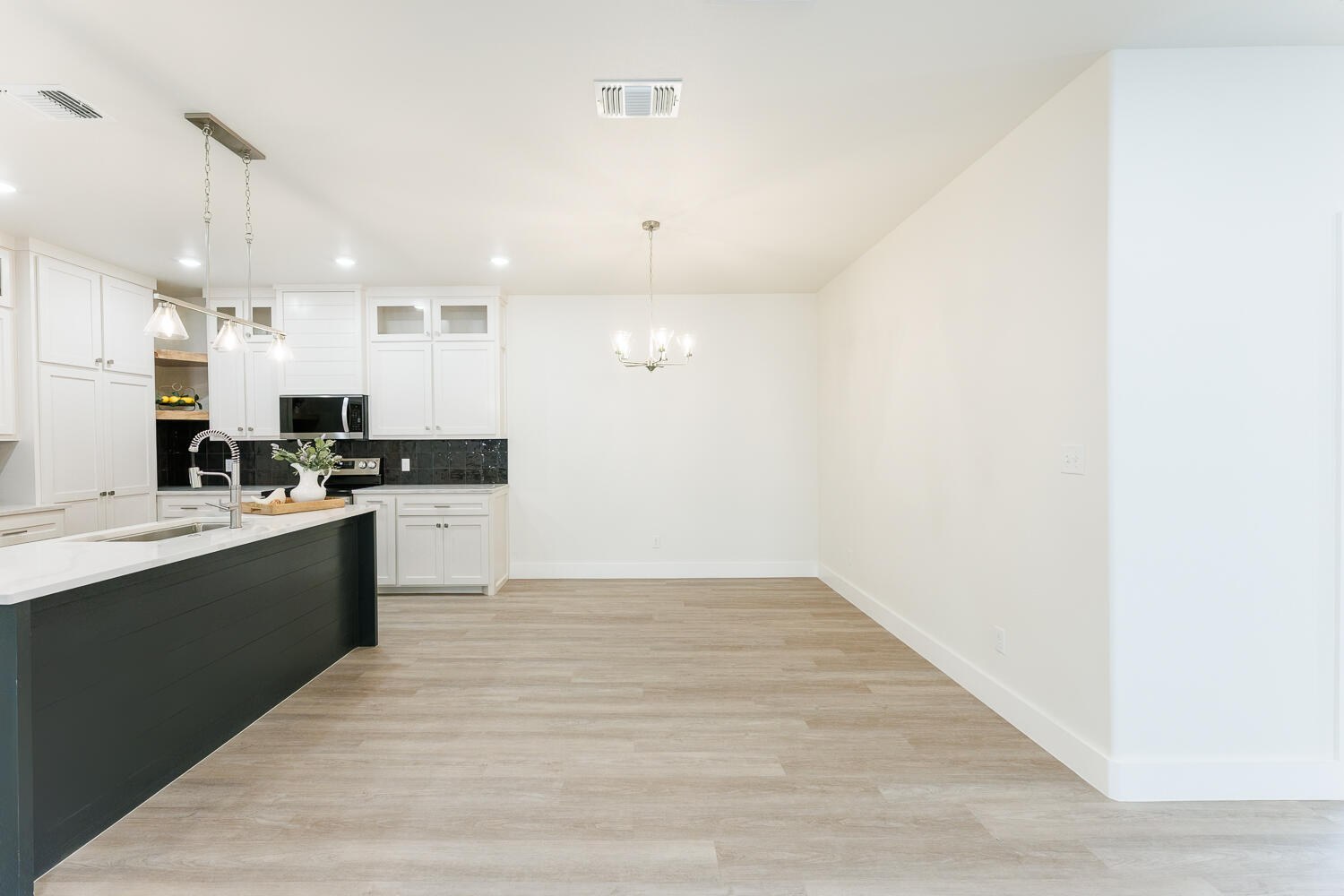 3819 58th Street Lubbock, TX 79413 - Photo 15 of 63 a large white kitchen with a sink and dishwasher a refrigerator with wooden floor