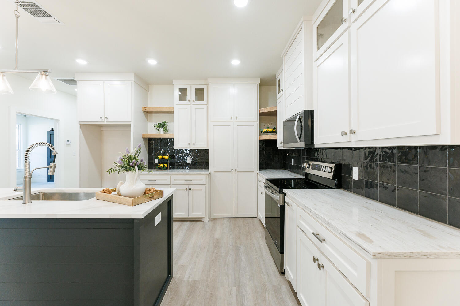 3819 58th Street Lubbock, TX 79413 - Photo 18 of 63 a kitchen with white cabinets sink and stainless steel appliances