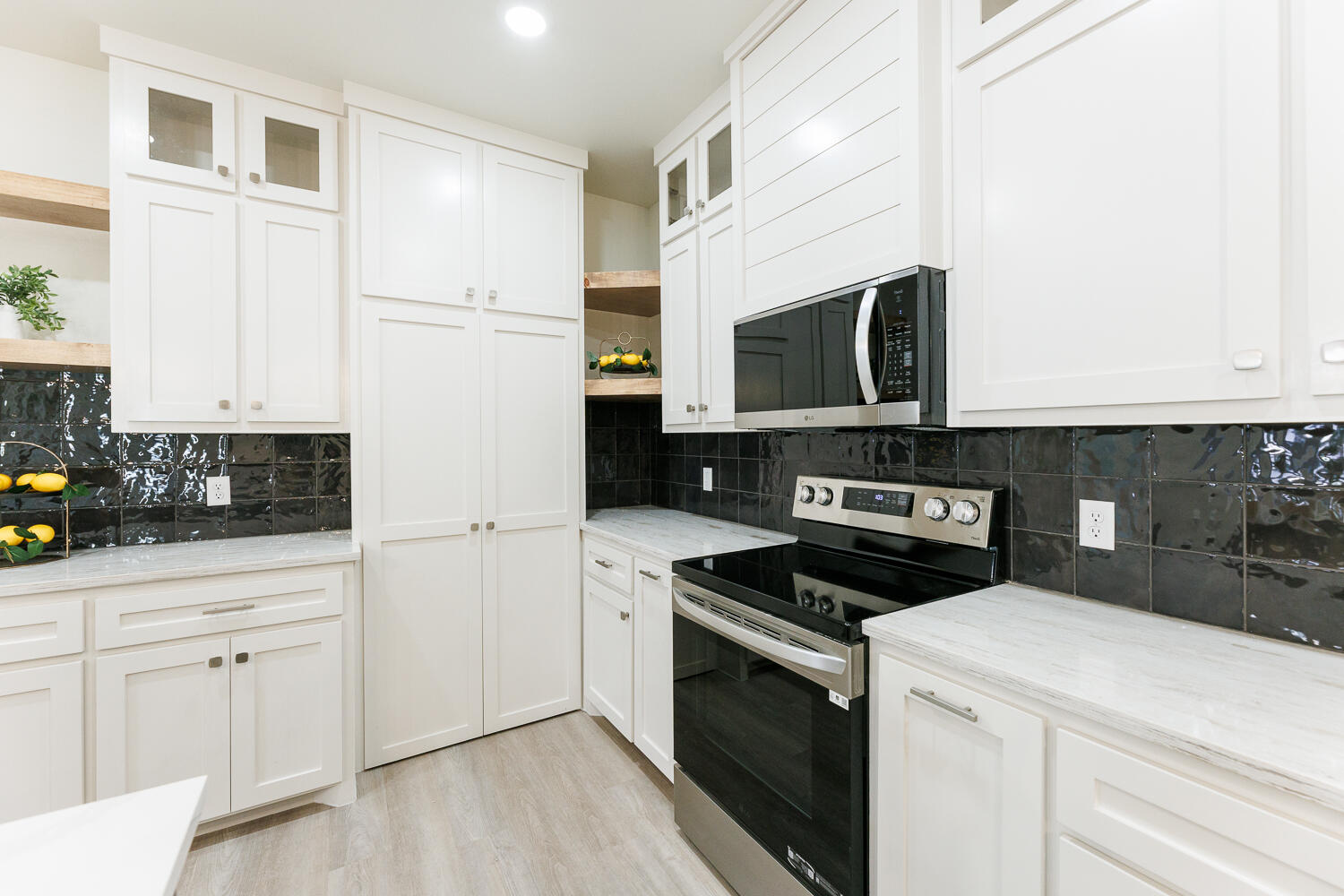 3819 58th Street Lubbock, TX 79413 - Photo 20 of 63 a kitchen with white cabinets and stainless steel appliances