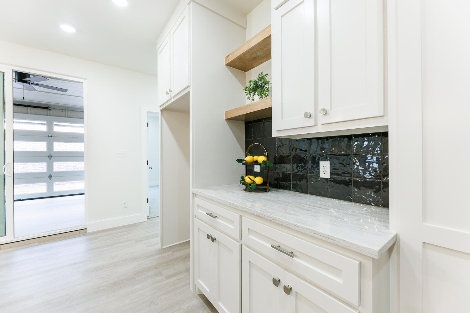 3819 58th Street Lubbock, TX 79413 - Photo 21 of 63 a kitchen with stainless steel appliances a white cabinets and a wooden floor