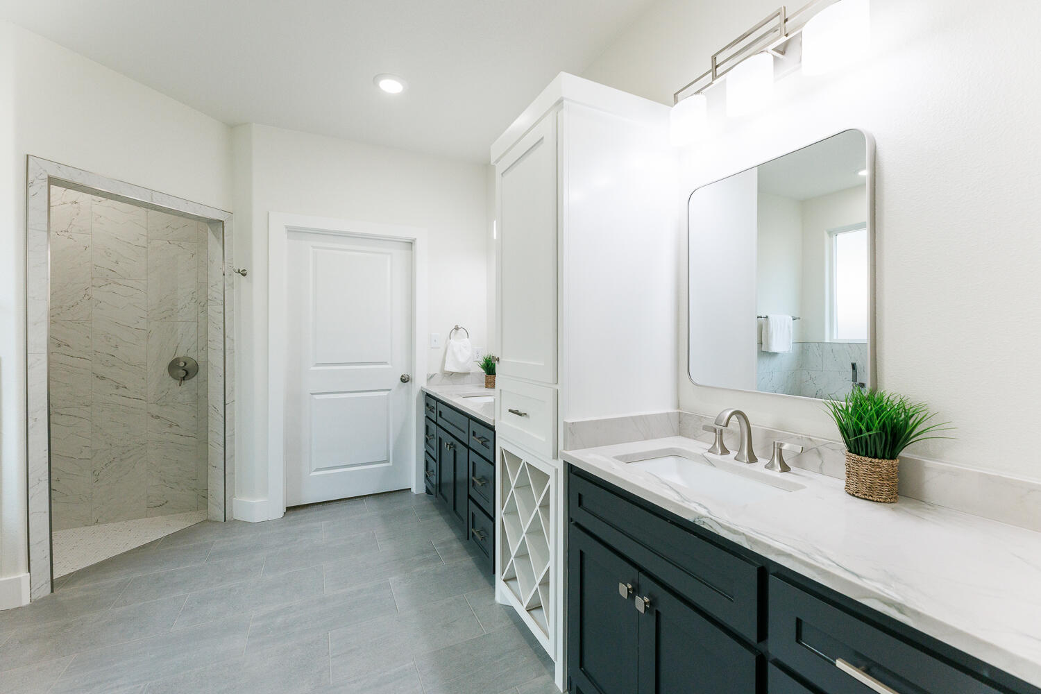 3819 58th Street Lubbock, TX 79413 - Photo 32 of 63 a spacious bathroom with a double vanity sink a large mirror and a shower