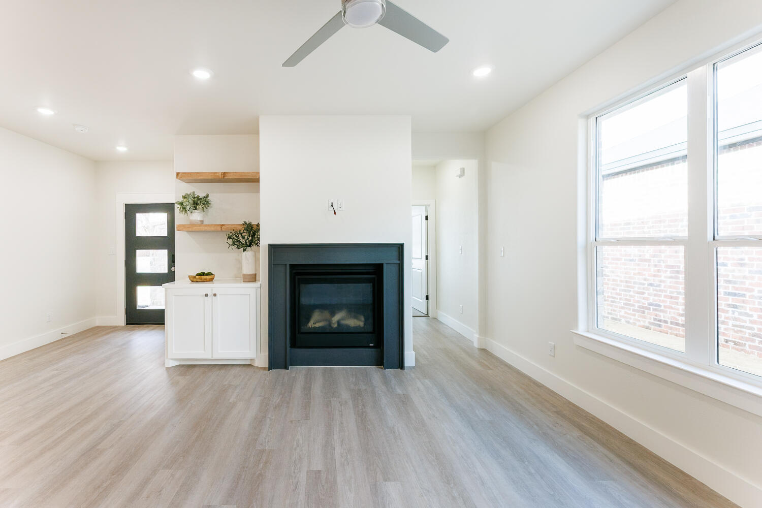 3819 58th Street Lubbock, TX 79413 - Photo 7 of 63 an empty room with windows and a fireplace