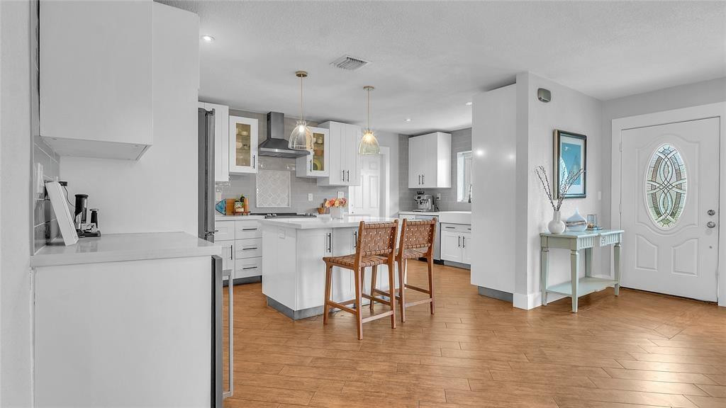 2800 Northeast 53rd Street Lighthouse Point, FL 33064 - Photo 11 of 34 a kitchen with stainless steel appliances granite countertop a refrigerator a stove and white cabinets with wooden floor