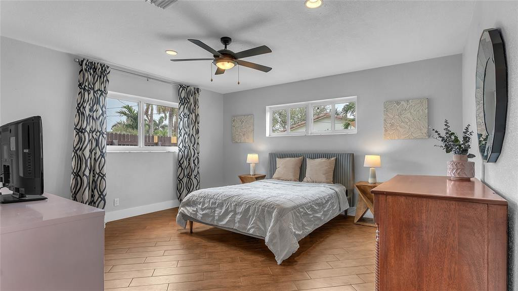2800 Northeast 53rd Street Lighthouse Point, FL 33064 - Photo 27 of 34 a bedroom with a large bed chandelier and a window