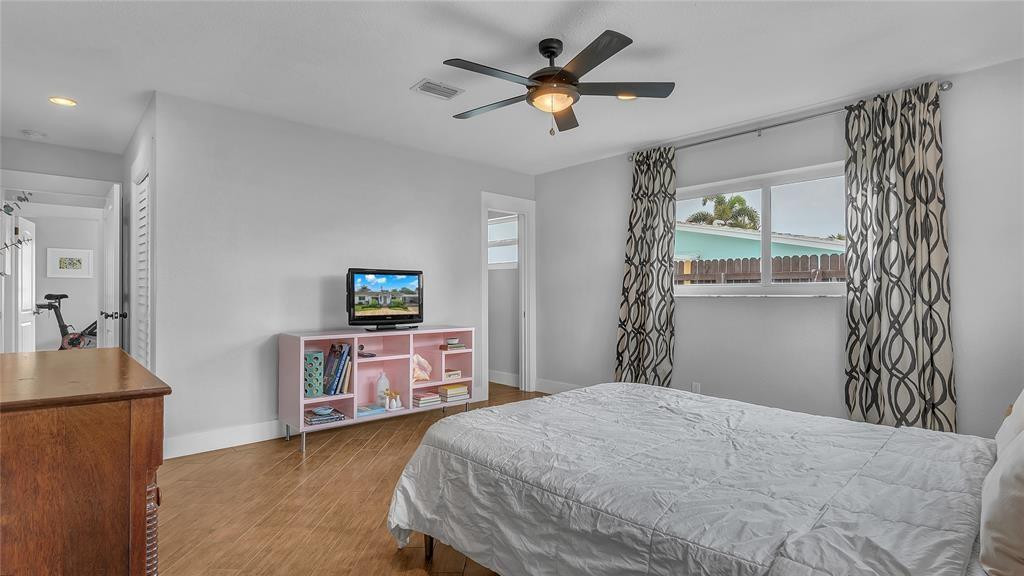 2800 Northeast 53rd Street Lighthouse Point, FL 33064 - Photo 28 of 34 a bedroom with a bed and a chandelier