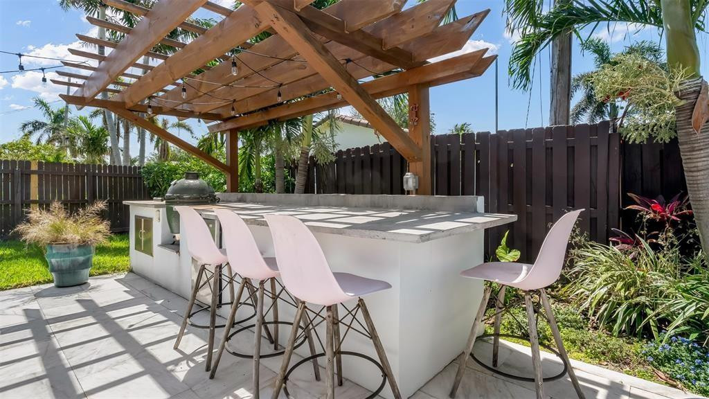2800 Northeast 53rd Street Lighthouse Point, FL 33064 - Photo 29 of 34 a view of a patio with table and chairs potted plants and wooden fence