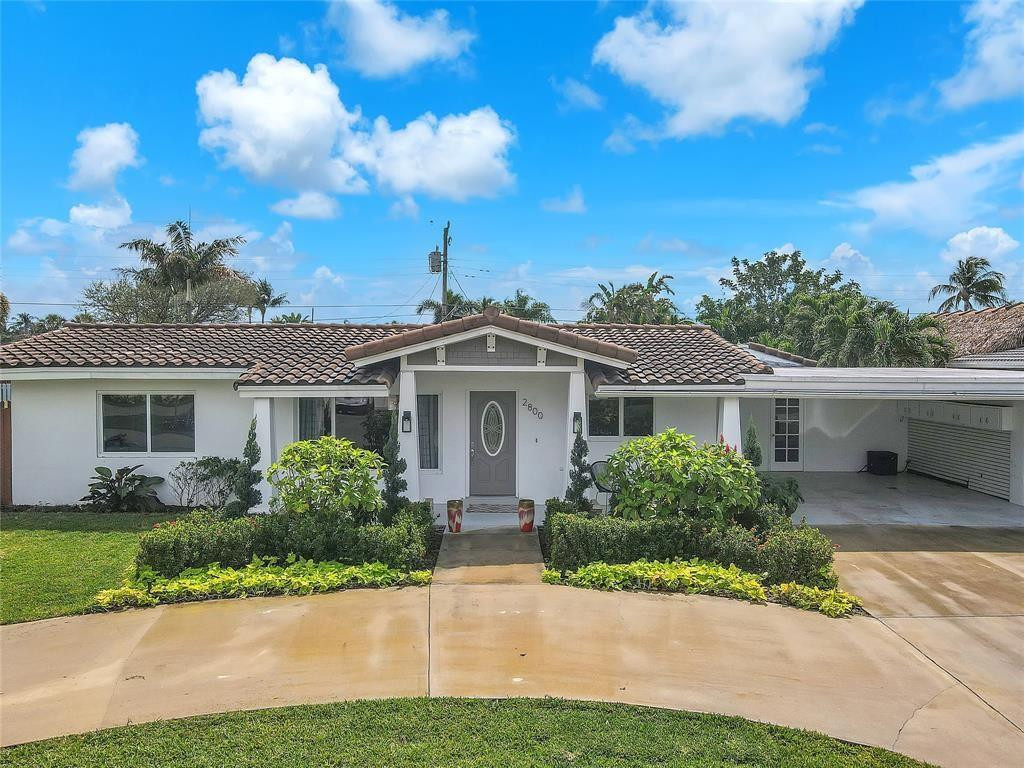2800 Northeast 53rd Street Lighthouse Point, FL 33064 - Photo 4 of 34 a front view of a house with a garden