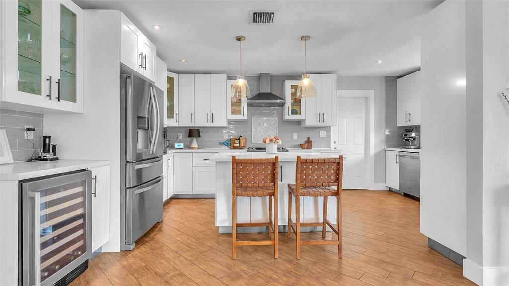 2800 Northeast 53rd Street Lighthouse Point, FL 33064 - Photo 6 of 34 a kitchen with white cabinets and stainless steel appliances