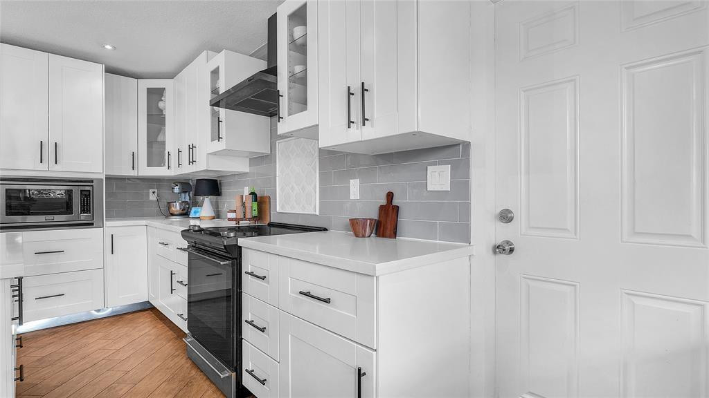 2800 Northeast 53rd Street Lighthouse Point, FL 33064 - Photo 8 of 34 a kitchen with white cabinets and stainless steel appliances