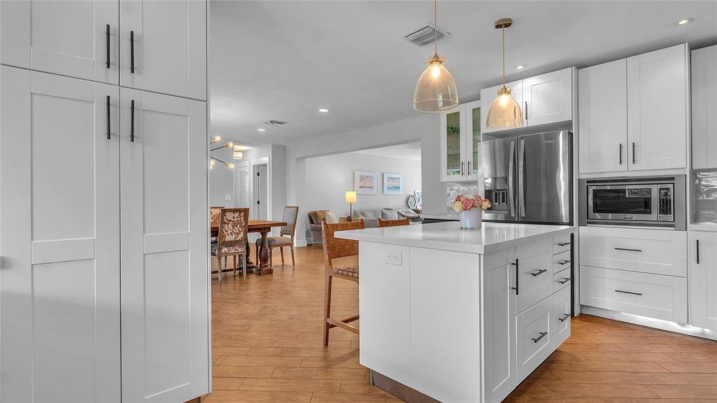 2800 Northeast 53rd Street Lighthouse Point, FL 33064 - Photo 9 of 34 a kitchen with white cabinets and stainless steel appliances