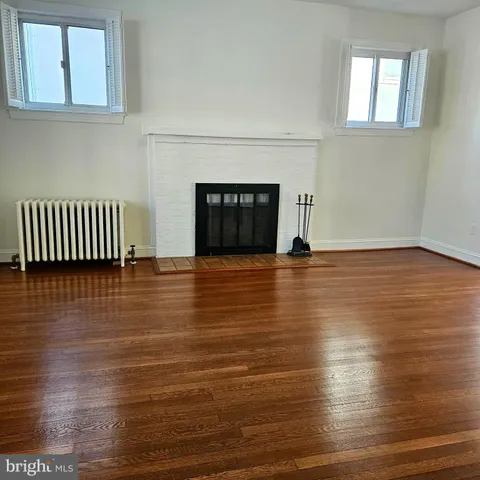 a view of empty room with wooden floor and fireplace