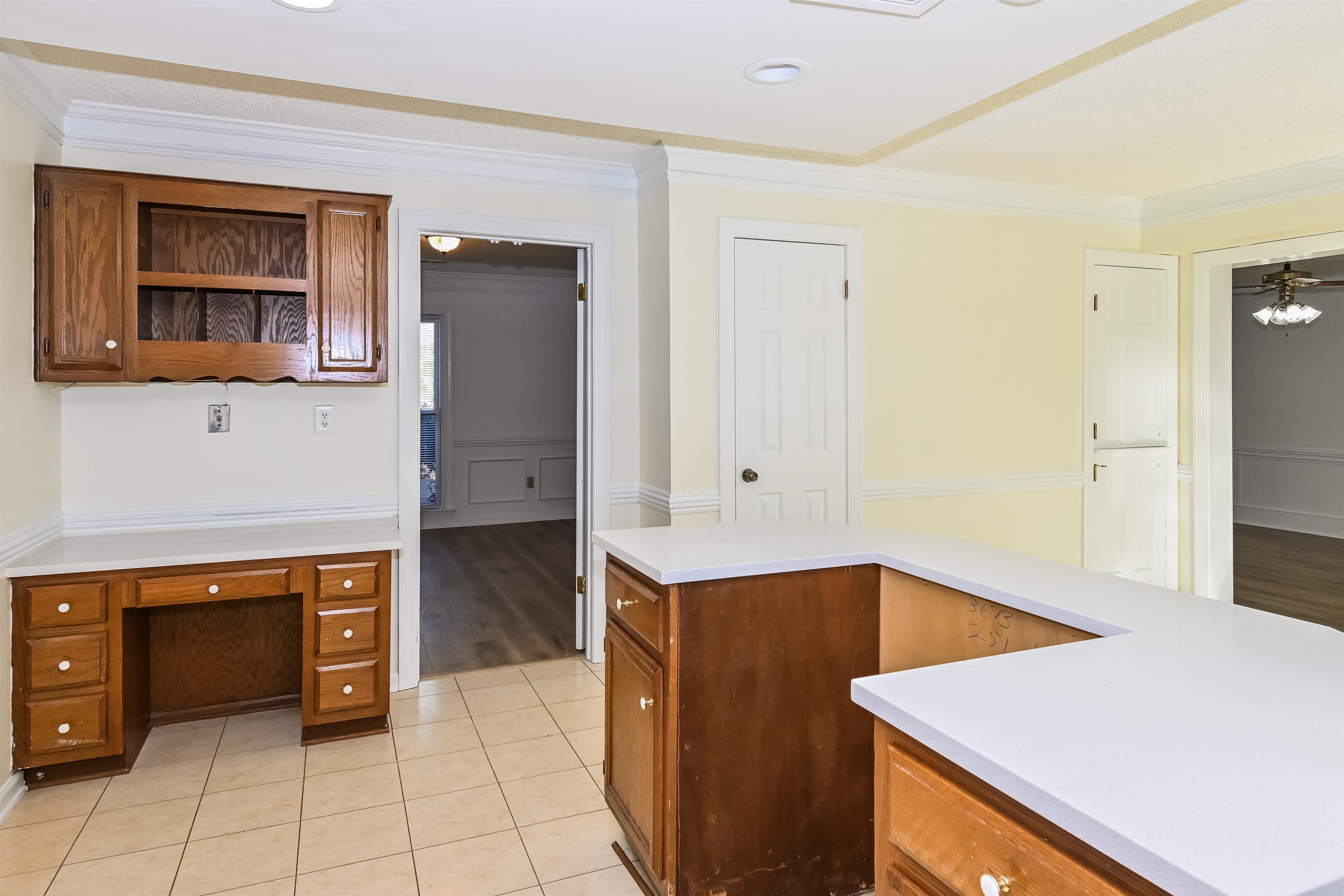 3656 Beaver Run Drive Collierville, TN 38017 - Photo 6 of 18 Kitchen featuring a wainscoted wall, wood finish cabinetry, crown molding, light tile patterned floors, and open shelves