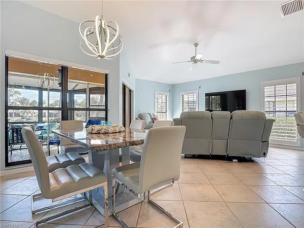 a living room with furniture a chandelier and a flat screen tv