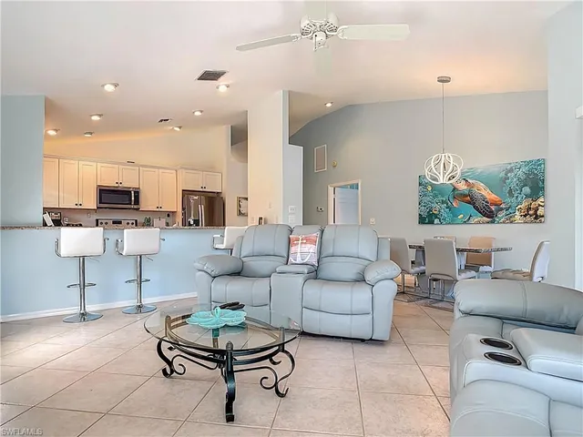 a living room with furniture kitchen view and a table