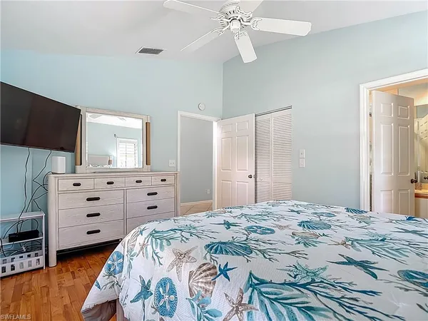 a bedroom with a bed and a flat tv screen on dresser