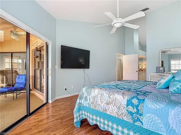 a bedroom with a large bed and a flat tv screen on dresser