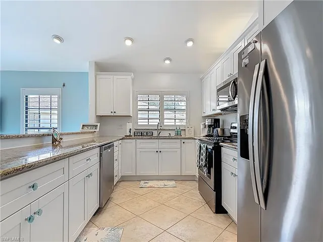 a kitchen with a sink refrigerator and window