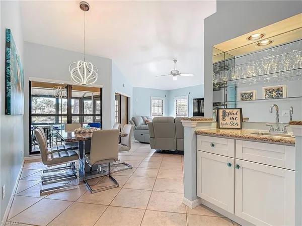 a living room with furniture a dining table and a floor to ceiling window