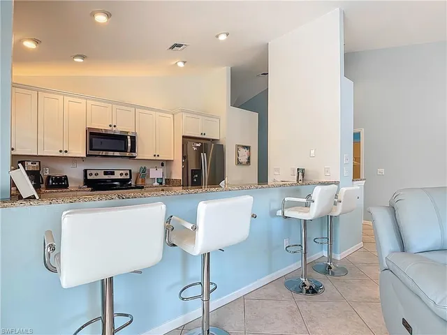 a kitchen with stainless steel appliances granite countertop a refrigerator a stove a sink and a stove