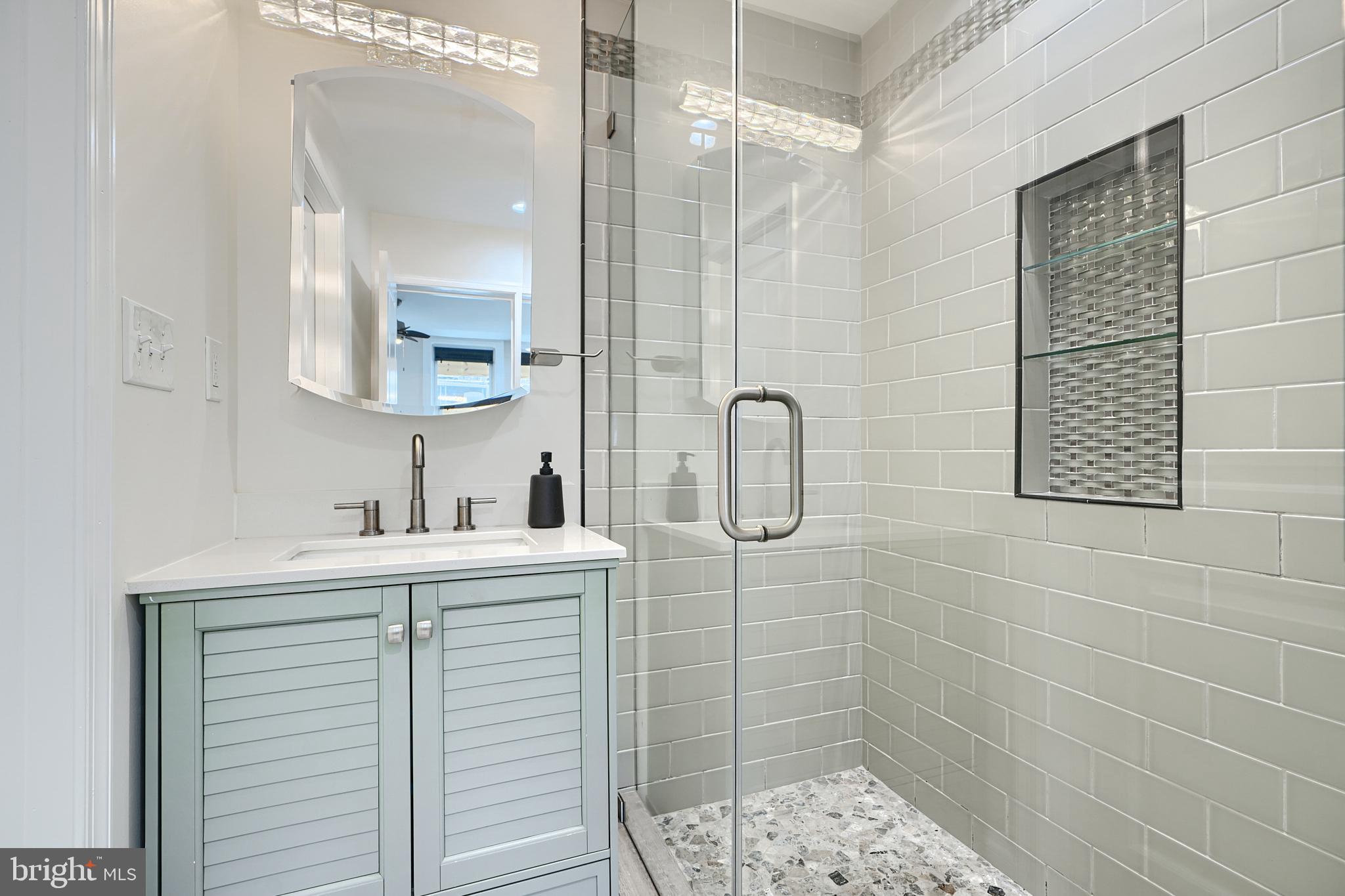 119 South Potomac Street Baltimore, MD 21224 - Photo 12 of 26 a bathroom with a shower a sink and a mirror