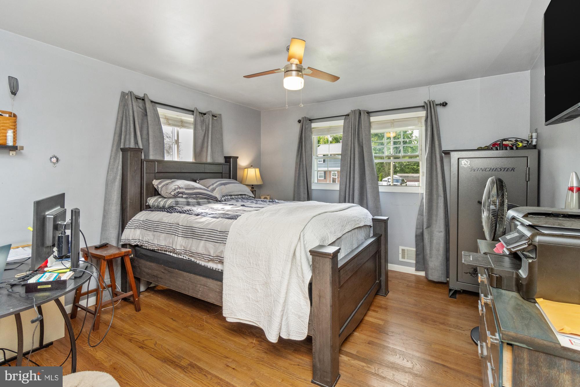 944 Homberg Avenue Baltimore, MD 21221 - Photo 17 of 50 a bedroom with a bed a dresser and wooden floor