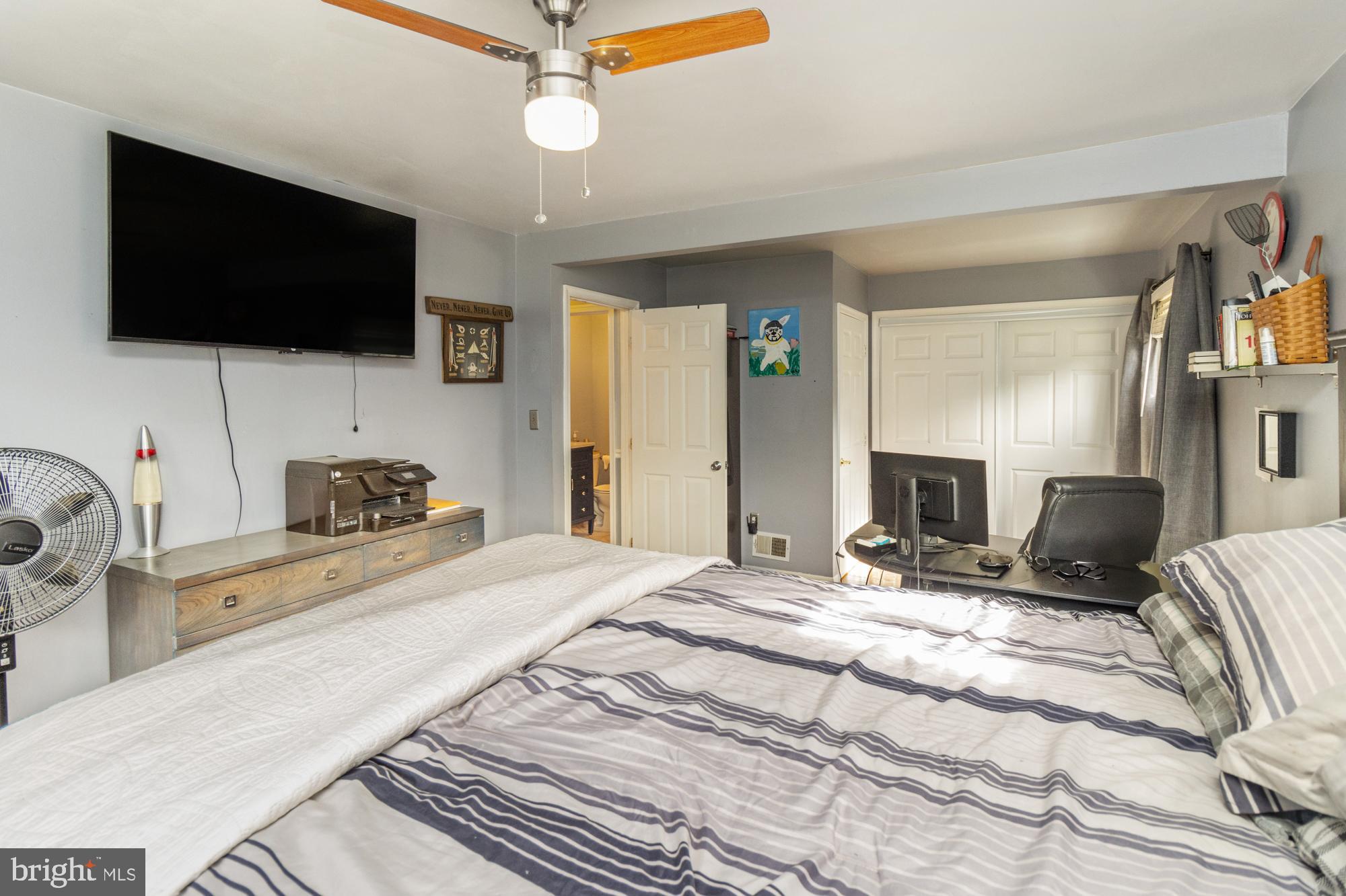 944 Homberg Avenue Baltimore, MD 21221 - Photo 19 of 50 a bedroom with a bed flat screen tv and a chandelier