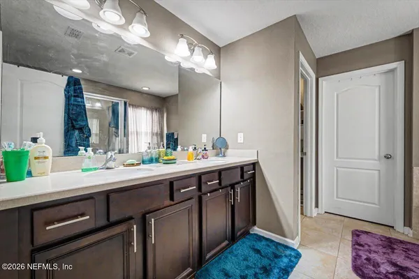 a spacious bathroom with a double vanity sink and a mirror