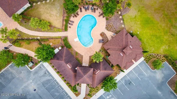 an aerial view of a house with a swimming pool and garden