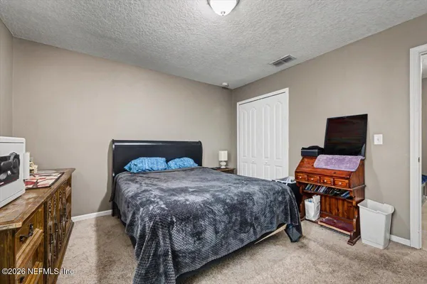 a bedroom with a bed and a tv on a dresser