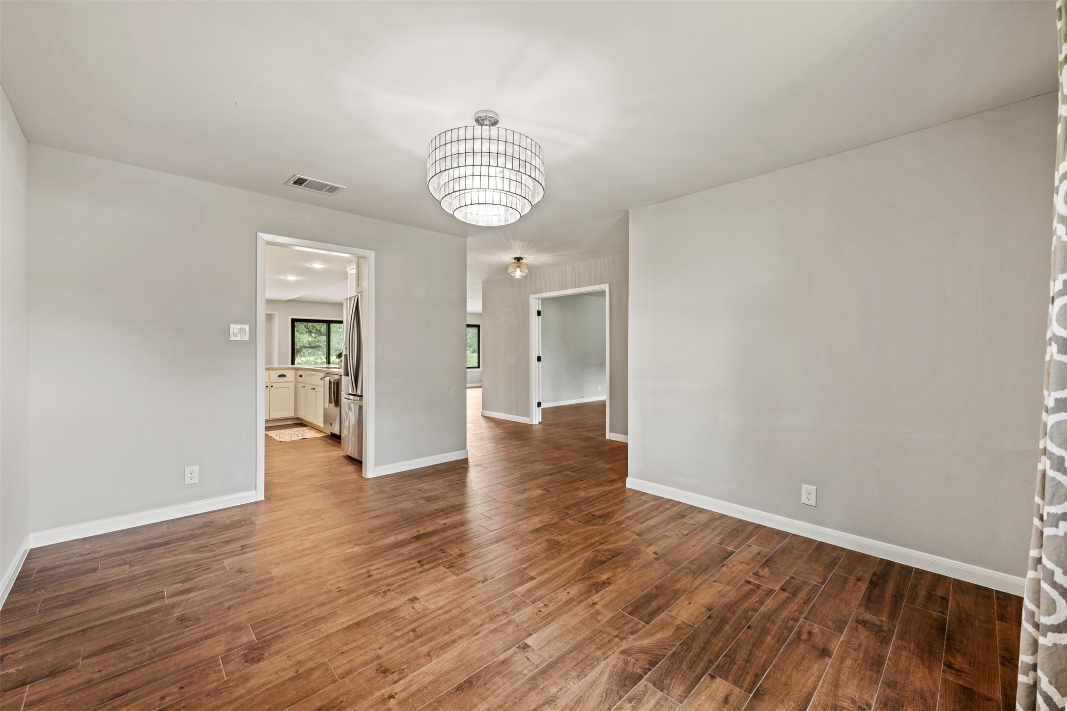 1600 Pin Oak Lane Round Rock, TX 78681 - Photo 10 of 40 Spacious room featuring wood-finish flooring, light gray walls, white baseboards, and a contemporary ceiling light fixture