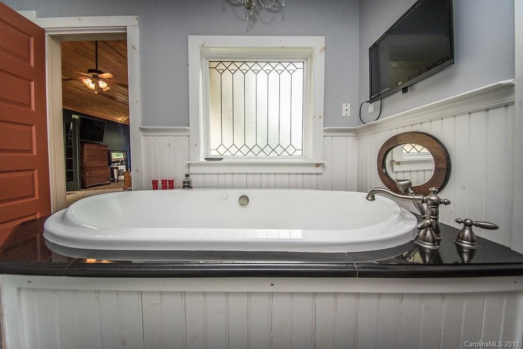 435 Landrum Road Columbus, NC 28722 - Photo 10 of 22 a bathroom with a bathtub and a window